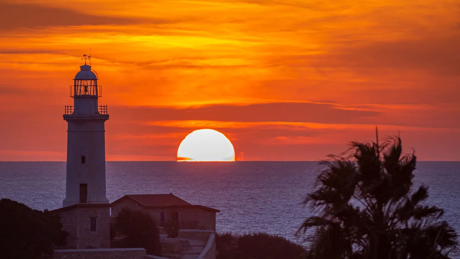 Farul din Paphos la apus, cu soarele coborând în mare