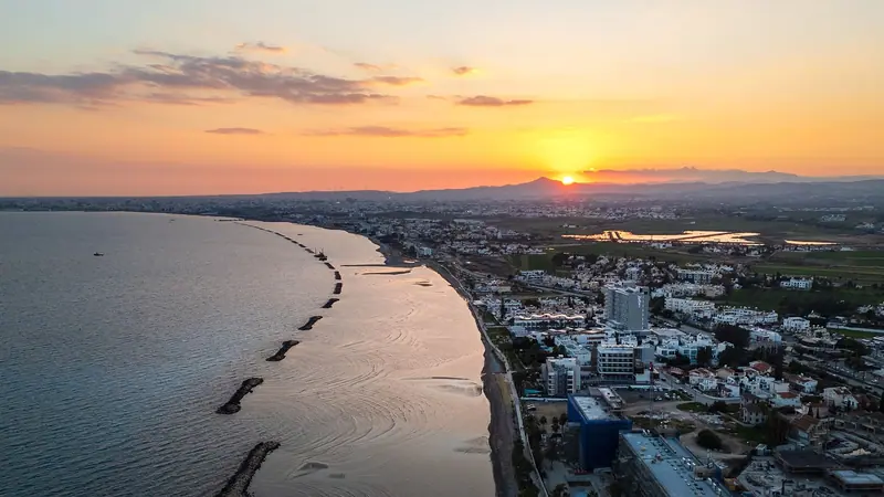 Küste von Zypern bei Sonnenuntergang, Luftaufnahme von Stadt und Strand